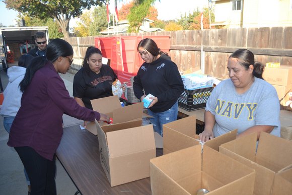 Volunteers pack boxes at Lemoore Christian Aid. From left to right are Shannon Mendoza, Soli Perez, Stephanie Bonilla and Soledad Perez.